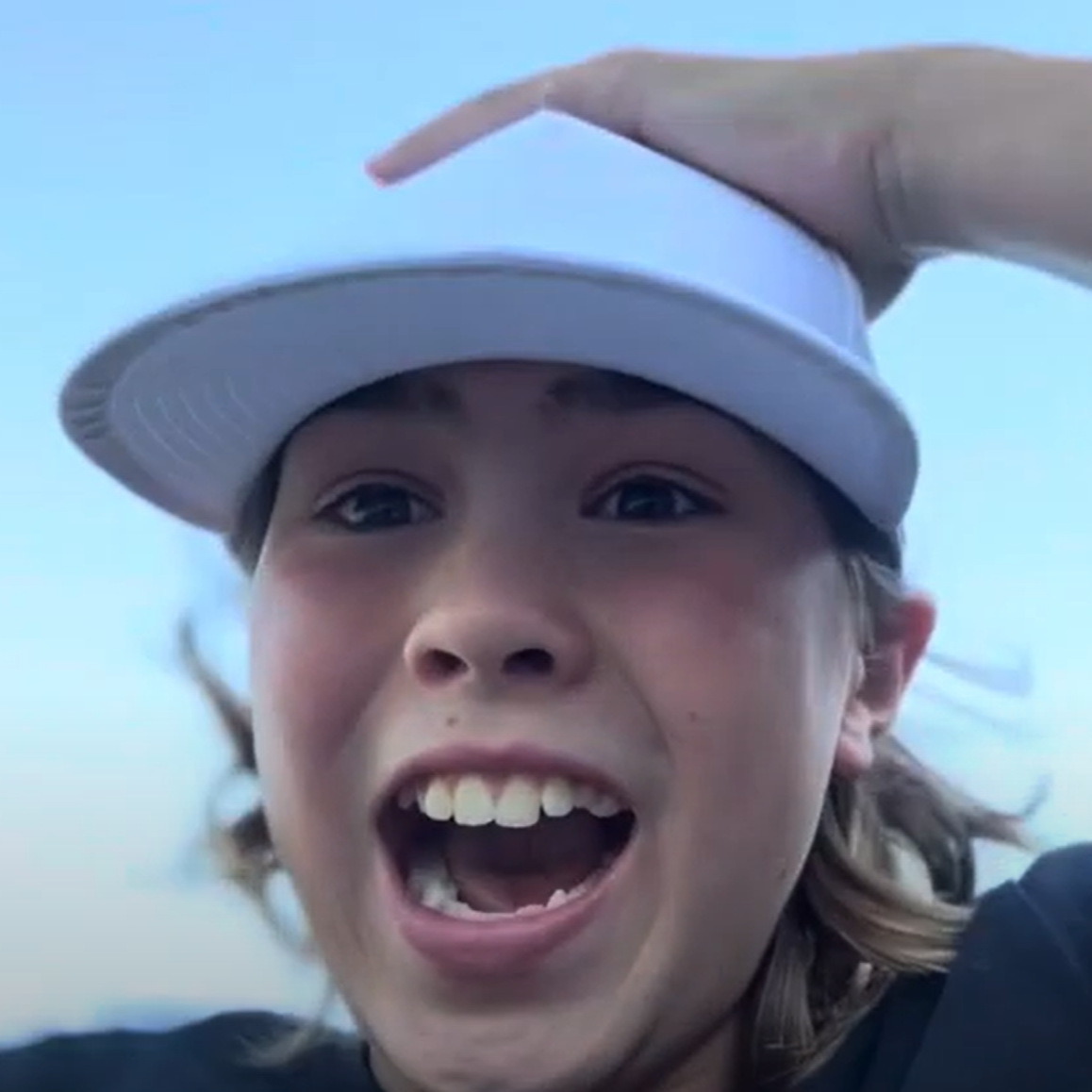 Chris wearing a white cap with a blue sky background and a shocked-happy look on his face